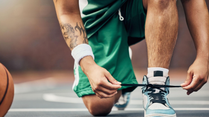 seseorang menali sepatu sebelum bermain basket
